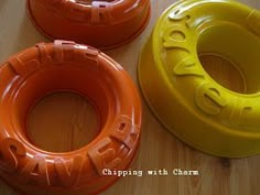 three orange and yellow floats sitting on top of a wooden table next to each other