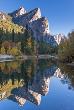 the mountains are reflected in the still water