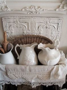 some white vases sitting on top of a shelf next to a wicker basket