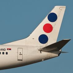 the tail end of an airplane that is painted in red, white, and blue