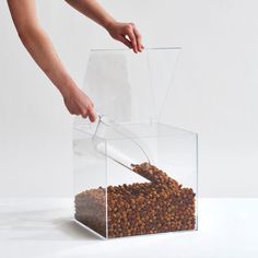 a person scooping food out of a clear box