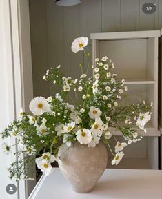 a vase filled with white flowers on top of a table