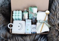 an open box filled with various items on top of a fur covered floor next to a cup