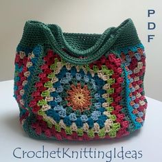 a multicolored crocheted purse sitting on top of a white table next to a wall