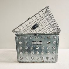 an old metal basket is sitting on a table