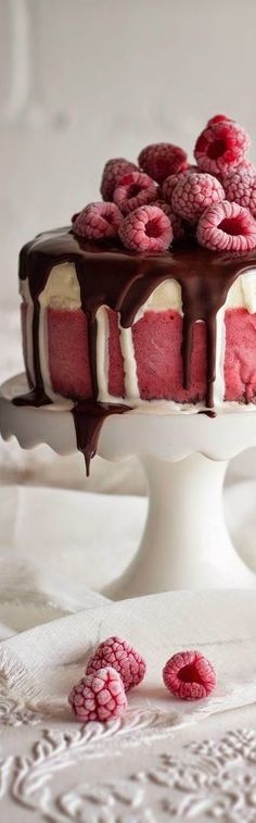 a cake with raspberries and chocolate on top