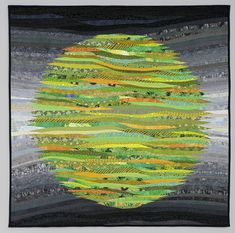 a quilted wall hanging with green and yellow stripes on the bottom, along with black background