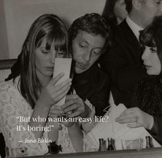 three women sitting next to each other looking at something on a cell phone with an old quote above them