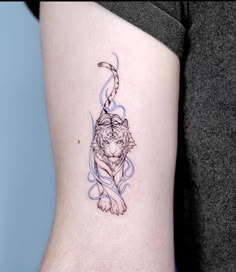 a small tiger tattoo on the left side of the right arm, with a crescent around it's neck