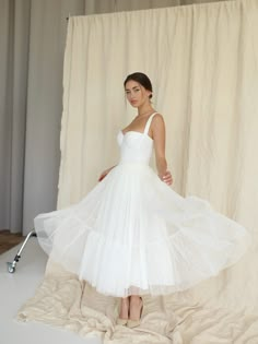 a woman standing in front of a white backdrop