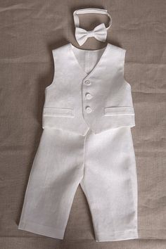 "Baby boy white linen outfit includes SET of 4 : - Vest - Pants - Shirt - Bow tie Shirt, pants and bow tie are made of linen. Vest made of eight-point star pattern linen cotton. The vest is fully lined with cotton fabric. Pants come in elastic waist adjustable with buttons and the bow tie is pre-tied with adjustable Velcro closure on the back. There is an available short or long sleeve shirt. If not specified there will be made long sleeve shirt as seen in the photo. You can order the appropriat Elegant White Linen Sets, Elegant White Suits For Baptism, Formal White Linen Sets, White Linen Formal Sets, Classic White Linen Set, Baby Boy White Outfit, Formal Boys Outfit, White Linen Outfit, Natural Clothes