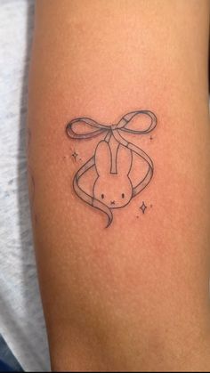 a rabbit tattoo with a bow on its head