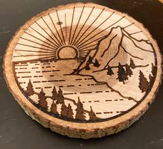 a wooden plate with trees and mountains on it