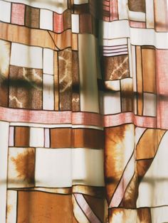 a close up view of a curtain with different colored squares and lines on the fabric