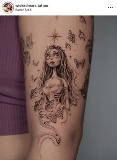 a woman's leg with a tattoo on it that has an image of a mermaid and butterflies