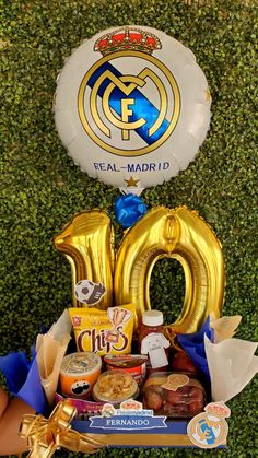 a table topped with balloons and confetti next to a sign that says real madrid