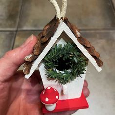 image of hand holding an ornament in the shape of a miniature birdhouse, with a small wreath around the opening and a mushroom at the bottom Christmas Bird Houses, Birdhouse Ornament, Recycled Planters, Birdhouse Ornaments, Room Scents, Christmas Bird, Bird Seed, Miniature Christmas, Bulb Flowers