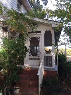 a small white house with a porch and window