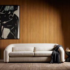 a white couch sitting in front of a wooden wall