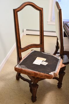 an old wooden chair with a piece of paper on it's seat next to a piano