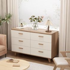 a living room scene with focus on the dresser and flowers sitting on top of it