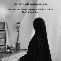 a black and white photo of a person in a nun outfit sitting on a bed