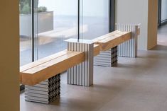 a wooden bench sitting in front of a glass wall