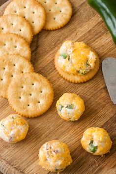 crackers and cheeses are arranged on a cutting board with a knife next to them