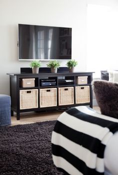 a flat screen tv sitting on top of a wooden entertainment center next to a couch