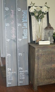 a tall wooden ruler next to a vase with flowers