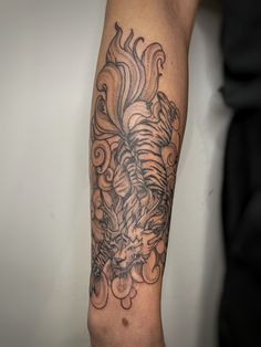 a man's arm with a dragon tattoo on it