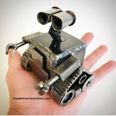 a hand holding a small metal object in it's left hand with two binoculars on top