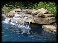 a small waterfall in the middle of a pool