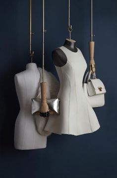 three mannequins are hanging on the wall next to each other with purses