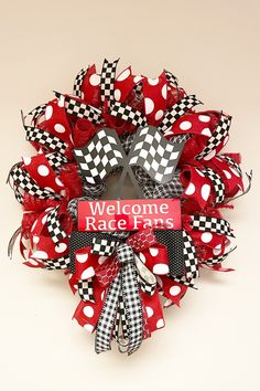 a welcome race fans wreath with red and black polka dots on the front, attached to a white wall