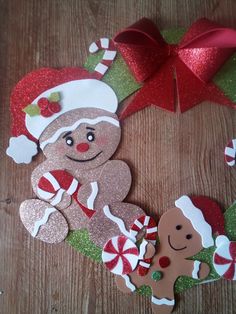 two gingerbreads are sitting next to each other on a wooden table with red and green decorations