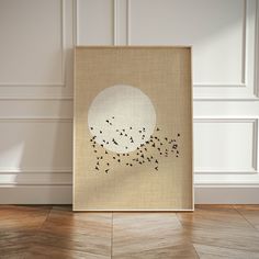 an art piece with birds flying in the sky on a wooden floor next to a white wall