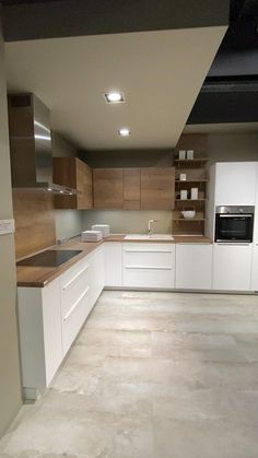 an empty kitchen with white cabinets and brown counter tops on the walls, along with no one in the room