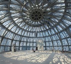 the inside of a large glass building with lots of light coming in from the ceiling