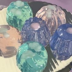 several different colored candles sitting on top of a plate