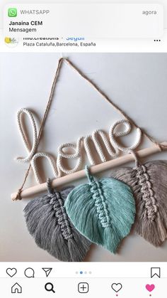 some tassels are hanging on a wall with the word home written in it