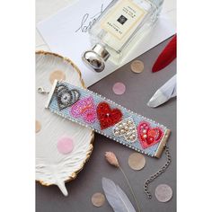 a white plate topped with a bottle of perfume next to a heart shaped keychain