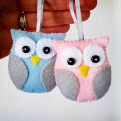 two felt owl ornaments hanging from a string