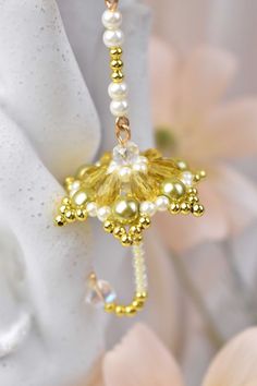 a close up of a flower with pearls on it's end and a beaded cross in the middle