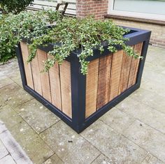 a wooden planter with plants growing out of it