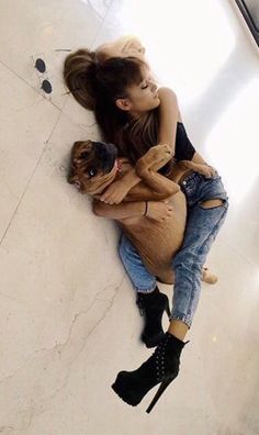 two people laying on the floor hugging each other with their arms around one another and looking down at them