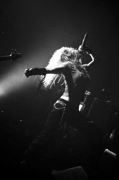 a woman standing on top of a stage with her arms out in front of the crowd