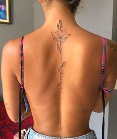 the back of a woman's body with tattoos on her upper and lower back