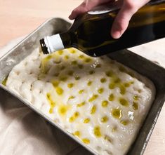 someone is pouring olive oil on top of some food in a pan with white rice