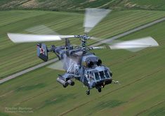 a helicopter flying over a lush green field